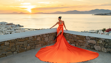 A breathtaking sunset moment in Mykonos — elegance in motion, captured with a vibrant flying dress overlooking the Aegean Sea.