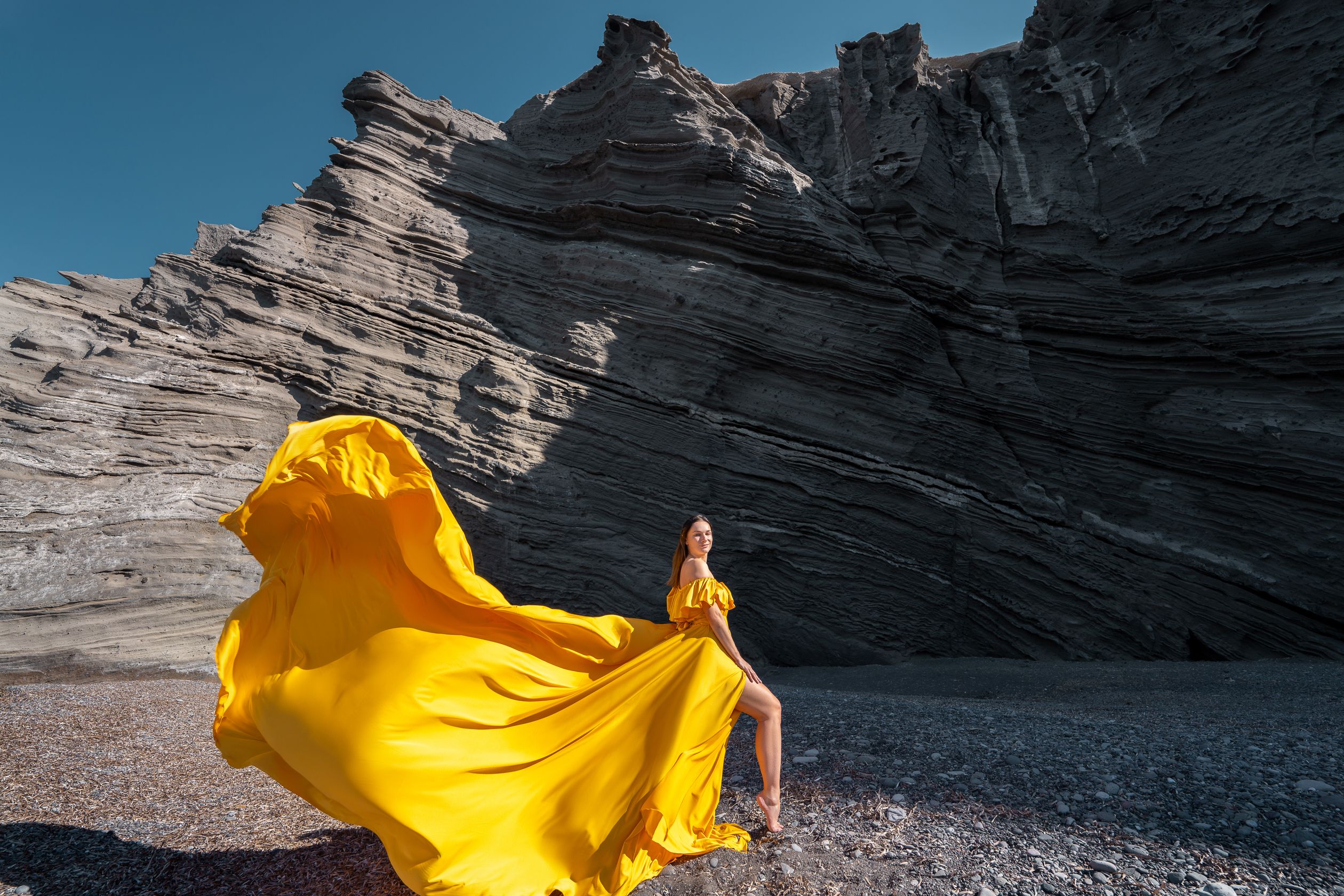 Black beach photoshoot with Santorini yellow dress
