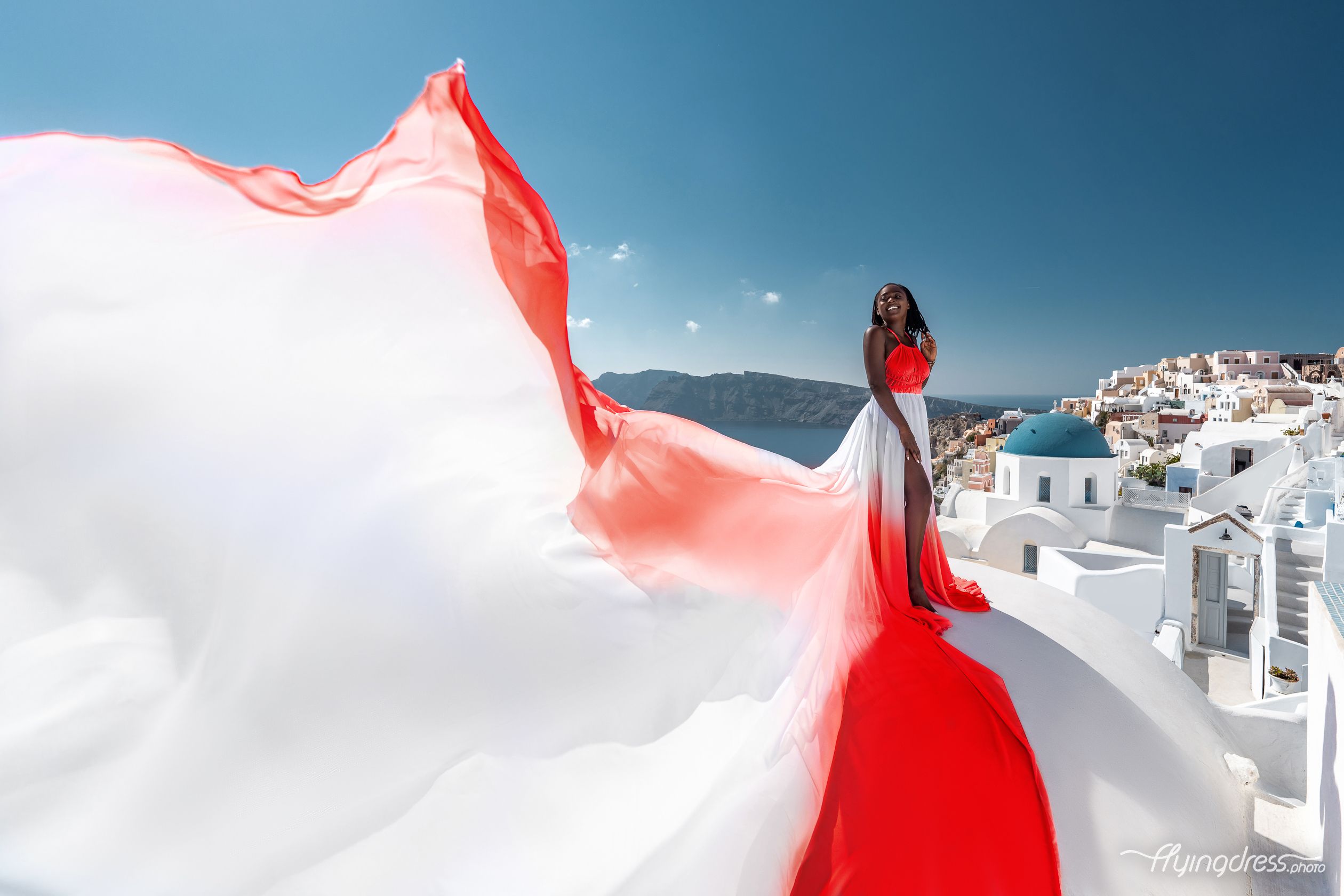 Red and white ombre flying dress photoshoot in Oia village, Santorini