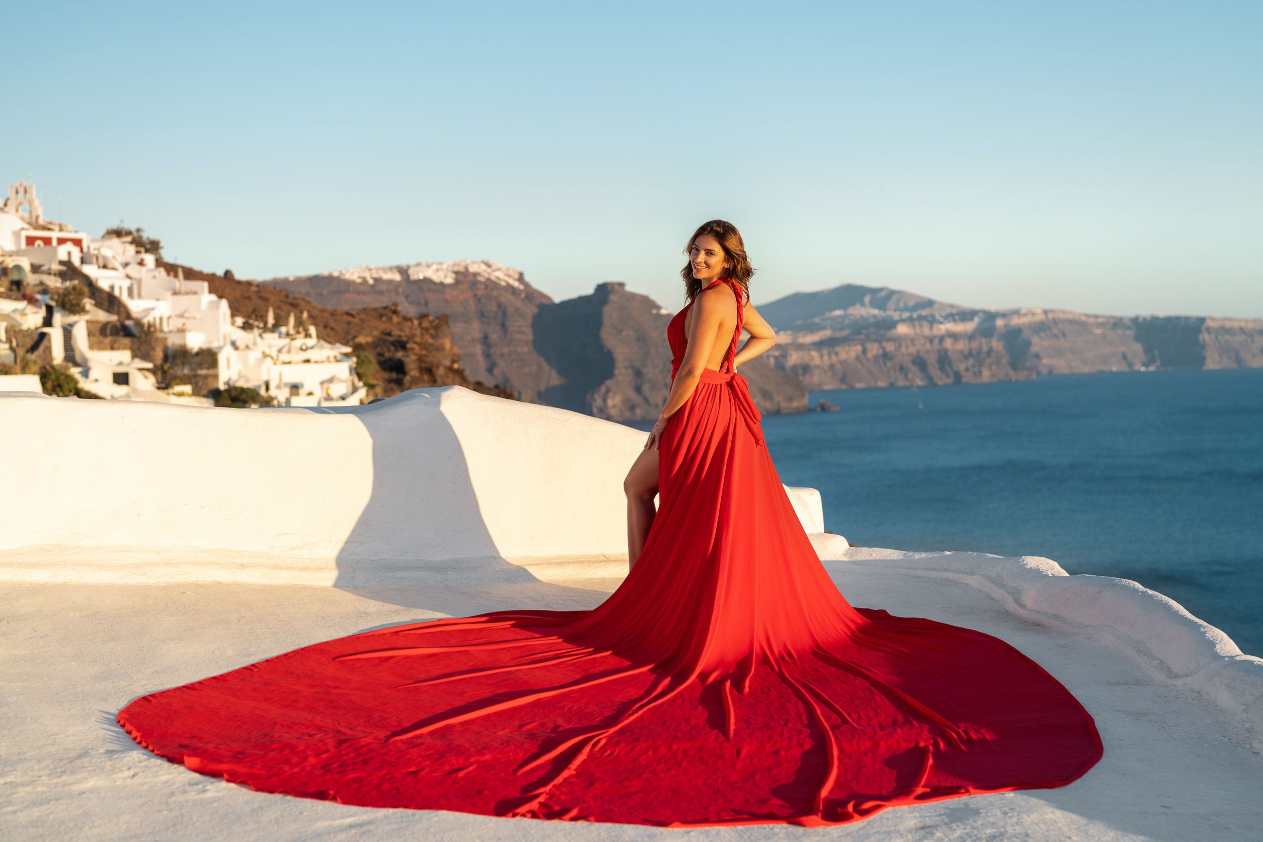 Flying Santorini red dress photoshoot in Oia