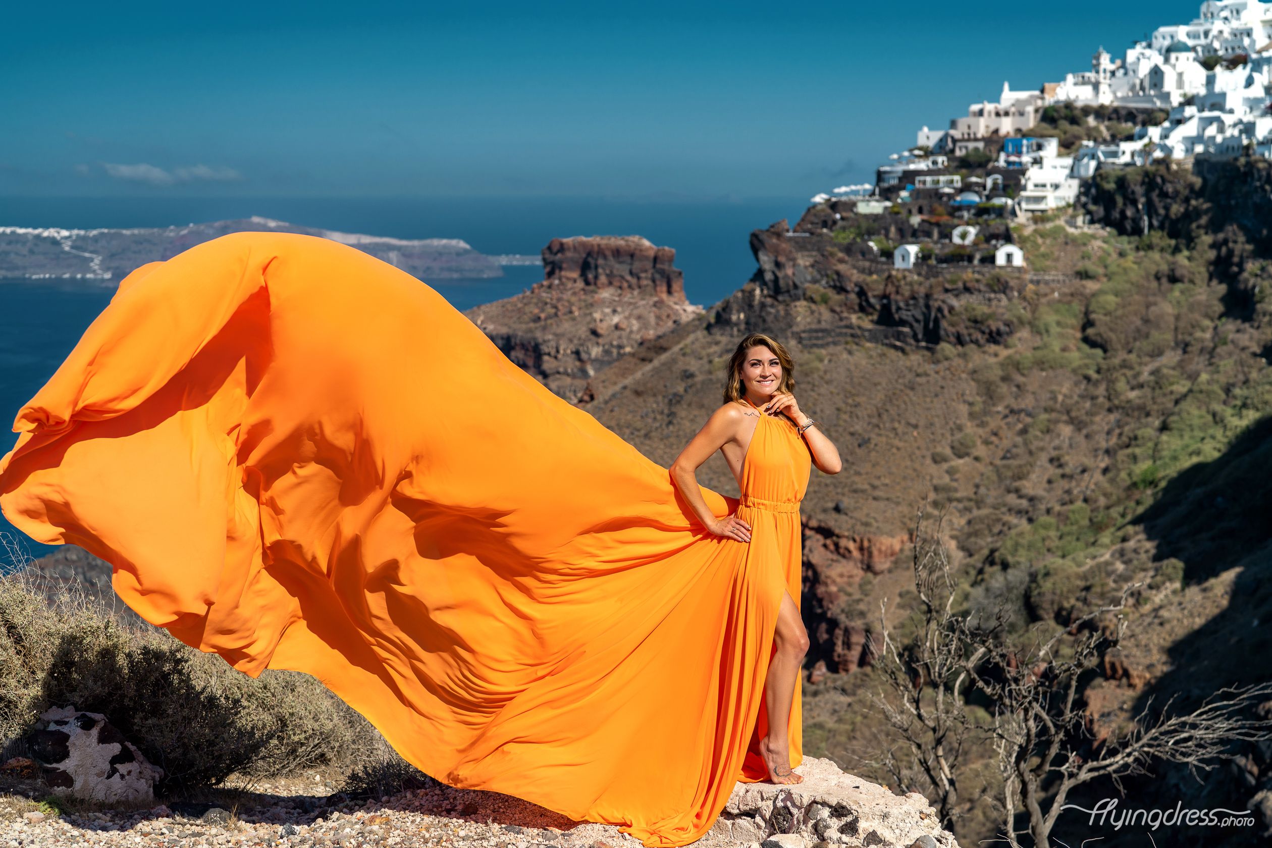 Santorini orange flying dress photoshoot with white houses