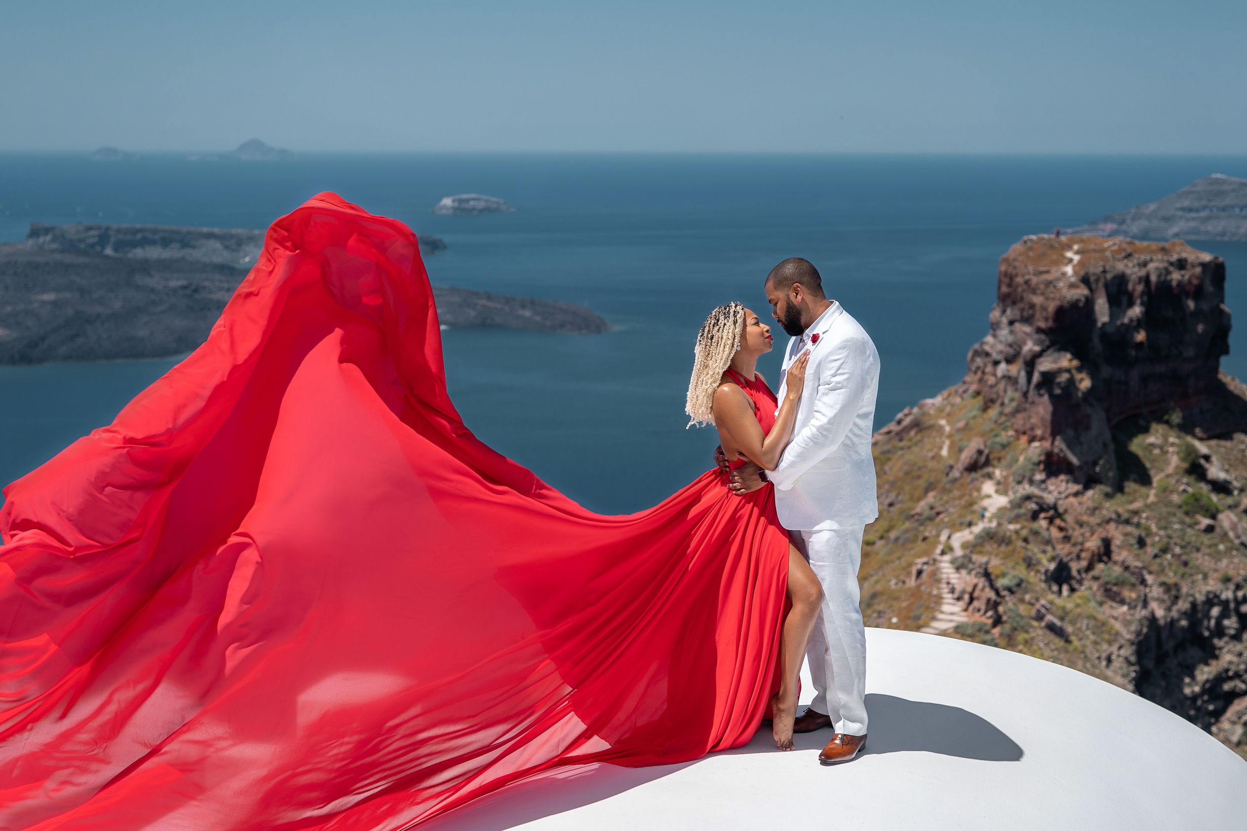 Santorini red flying dress photoshoot on a white roof