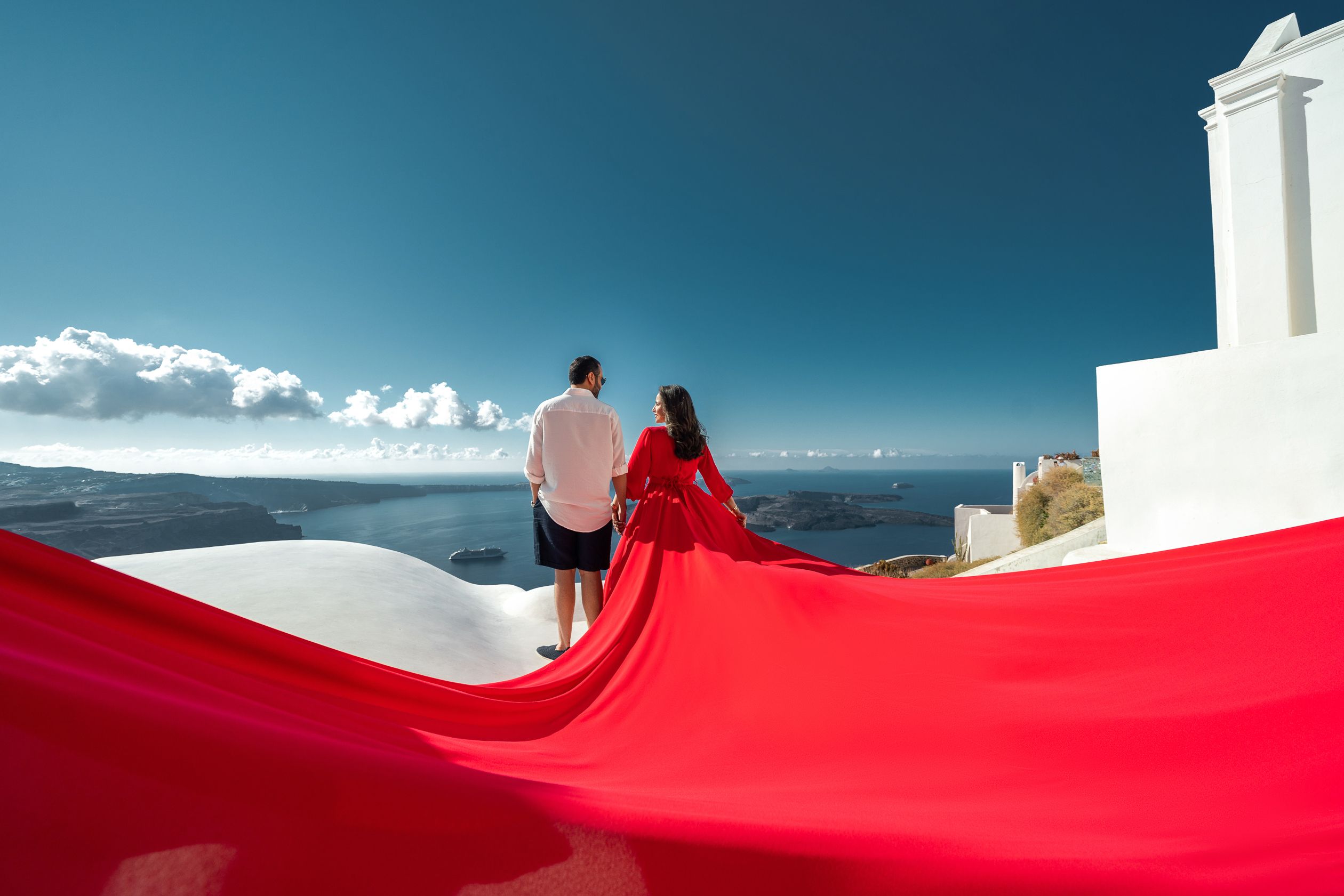 Red long sleeve flying dress photoshoot in Imerovigli, Santorini