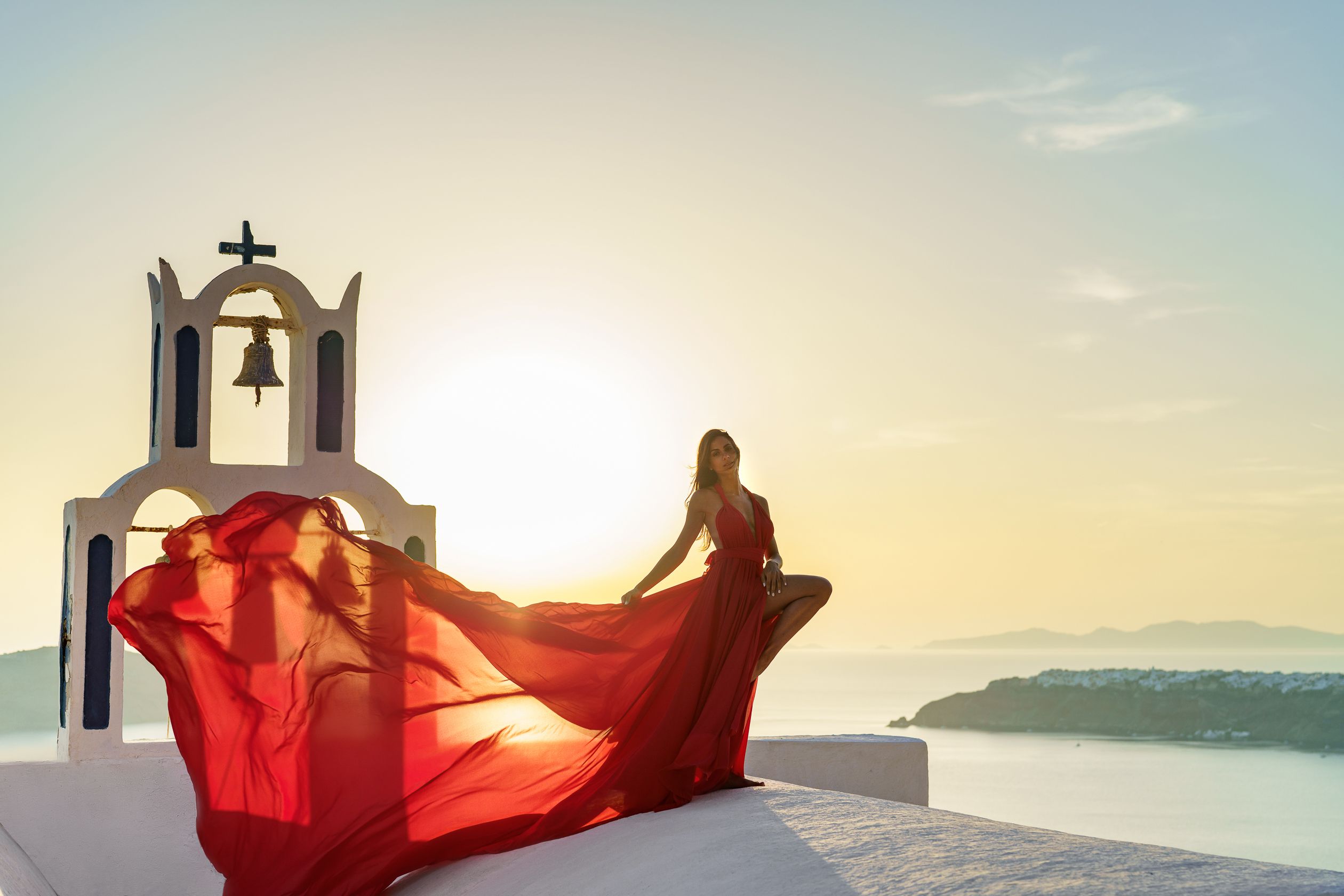 Sunset photoshoot with a red flying Santorini dress