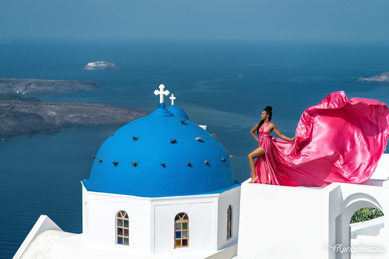 Flying dress photoshoot with the blue domes in Santorini, Greece