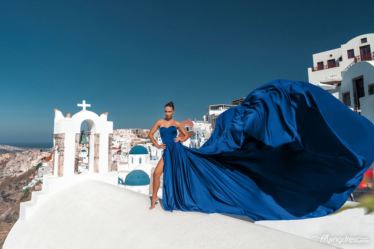 Flying dress photoshoot by the blue domes in Oia