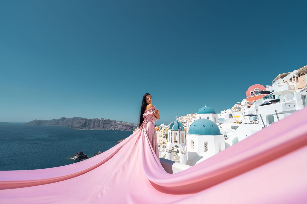 Santorini flying dress photoshoot with the blue domes in Oia
