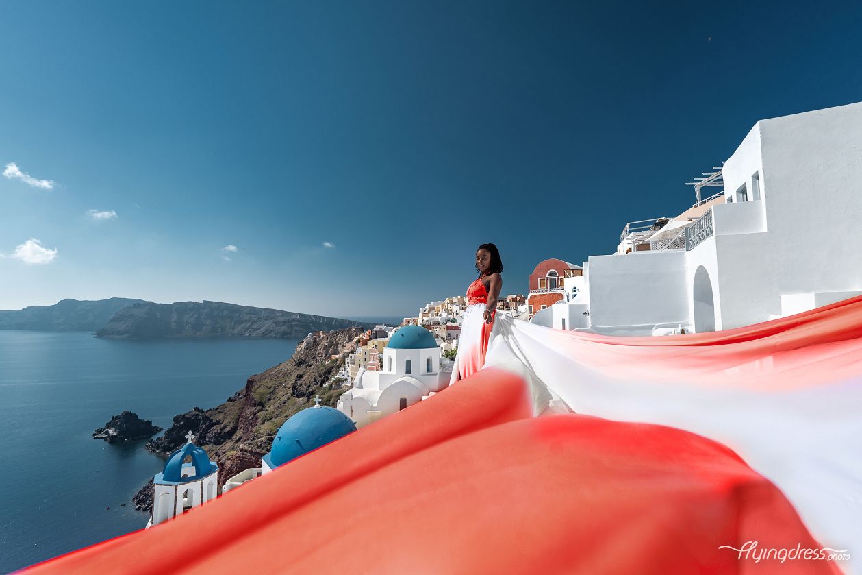 Flying dress photoshoot in Oia village by the blue domes
