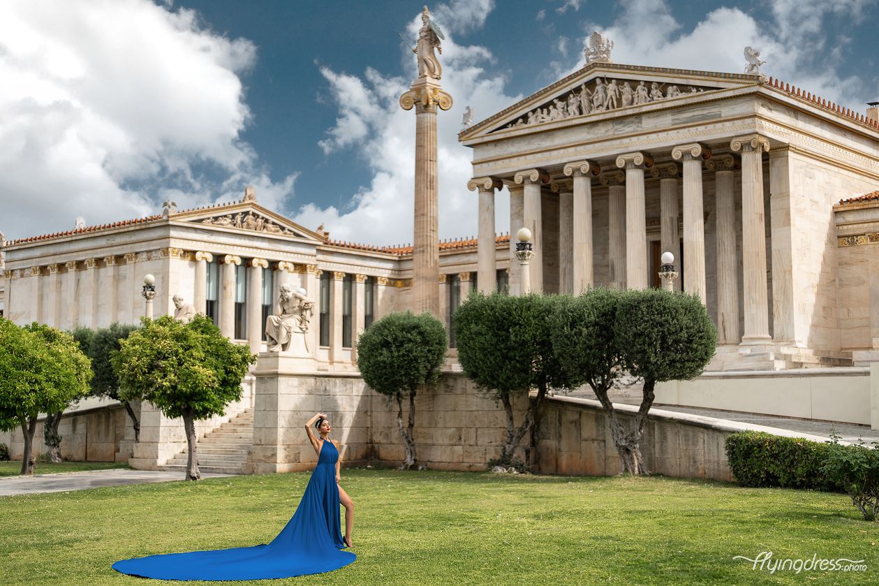 Set against the backdrop of Athens' iconic University, a model gracefully wears a flowing blue dress, embodying the city's timeless charm and elegance in a captivating photoshoot