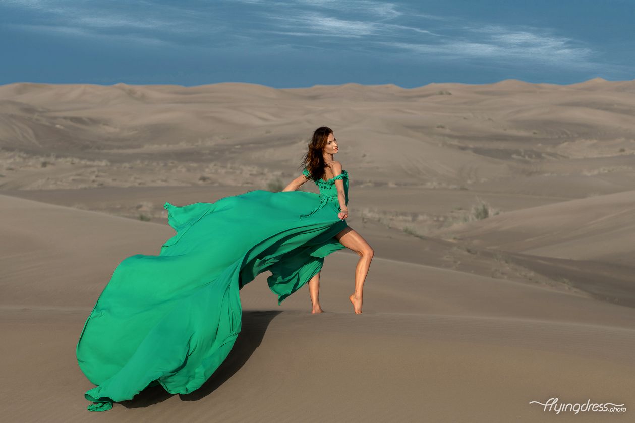 Experience enchantment in the desert as our model graces the landscape in a mesmerizing green flying dress.