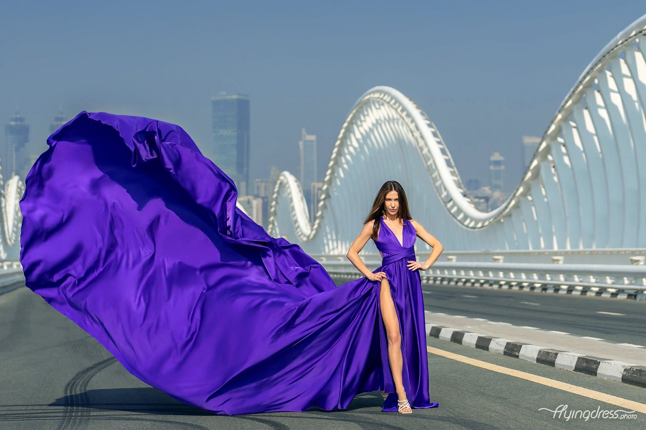 Dive into the surreal with our model in an ultraviolet dress on the bridge.