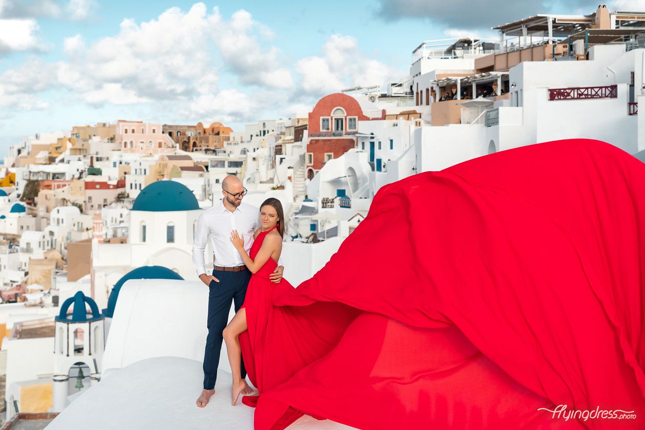 Photoshoot in Oia village with a white house and the blue domes in the background
