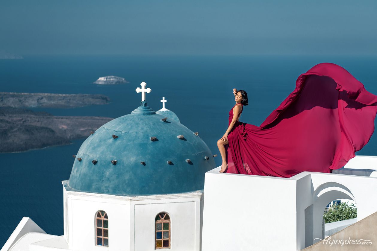 Flying Santorini dress photoshoot at Imervillas with the view of the blue domes, Imerovigli
