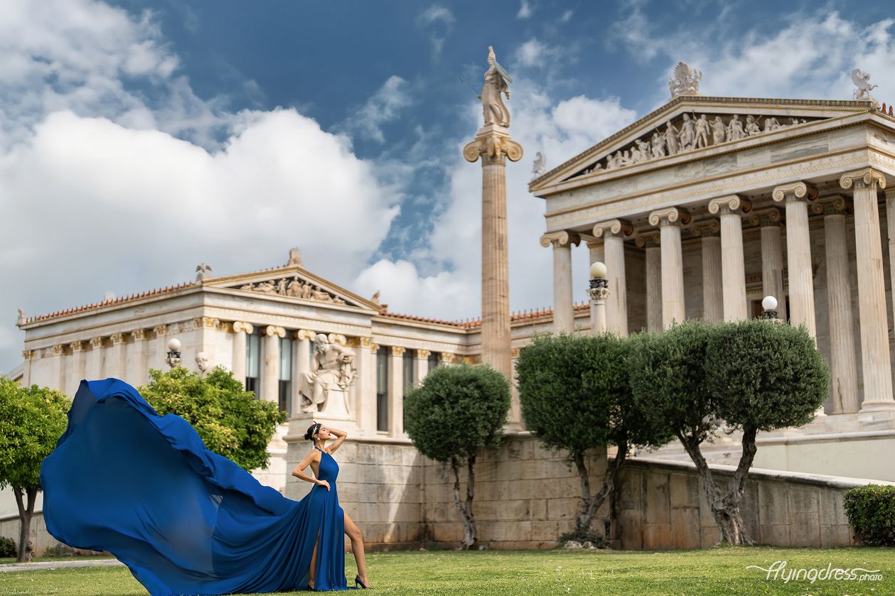 In the heart of Athens, a model in a blue flying dress graces the University, merging contemporary flair with the city's timeless charm in a stunning photoshoot