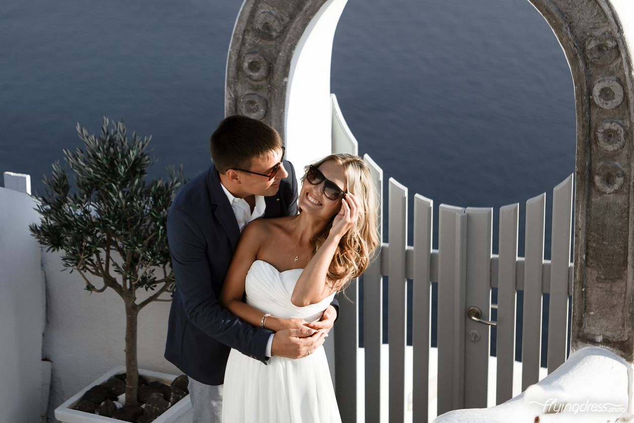 Embracing each other in a tender hug, a couple in Santorini's embrace, their love radiates warmth and affection, encapsulating the beauty of togetherness amidst the island's enchanting ambiance.