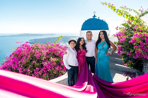 Family flying dress photoshoot by the blue dome in Santorini