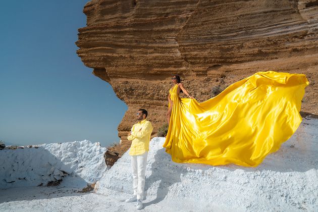 Flying dress shoot in Santorini with a volcanic rock formation