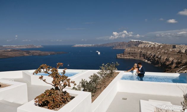Embracing the serenity of Santorini's caldera view, a couple shares a tender moment in the pool, their connection deepening amidst the captivating beauty of the island, creating an image of love and tranquility that will forever be cherished.