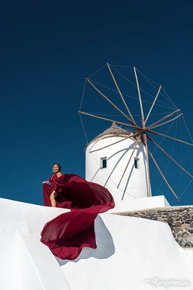 Flying dress photoshoot in Oia village close to the windmill