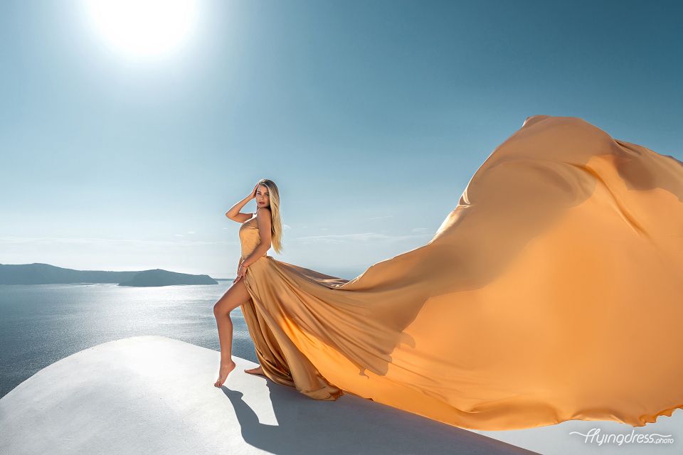 Flying Santorini dress photoshoot with a gold corset in Imerovigli, Greece