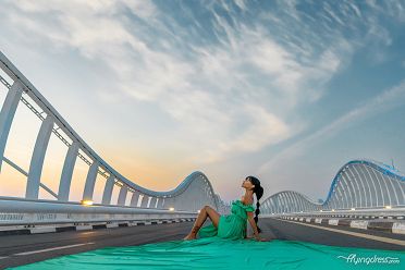 Chasing the sunset vibe on Maydan Bridge, our model sits gracefully on the road, adorned in a vibrant green flying dress.