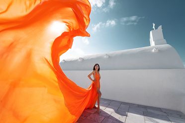 Photoshoot in Oia with an orange flying Santorini dress