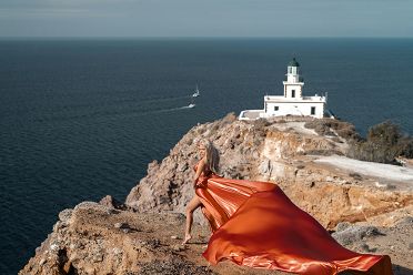 Flying dress photoshoot at the lighthouse of Santorini