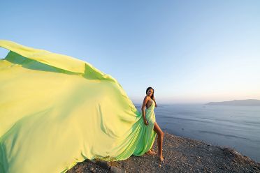 Green flying dress photoshoot with caldera view in Santorini