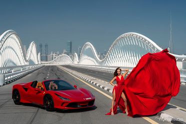 Embrace the morning allure on the bridge with our model adorned in a stunning red dress, capturing elegance next to a sleek Ferrari.