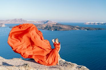 Red flying dress photoshoot in Santorini with caldera view