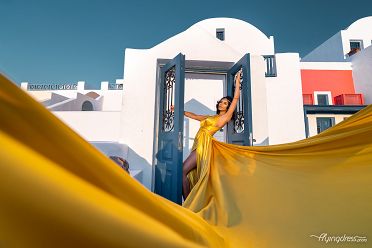 Sunset photoshoot with a yellow flying dress in Santorini