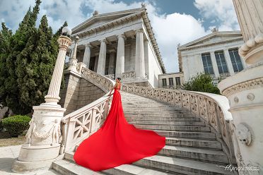 In the grandeur of Vallianeio Megaron, a model commands attention in a vibrant red dress, capturing the essence of sophistication and allure during an unforgettable photoshoot.
