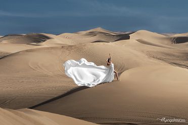 Young model Katia graces the Dubai desert, donning a beautiful white flying dress, capturing elegance in the serenity of golden sands and endless horizons.